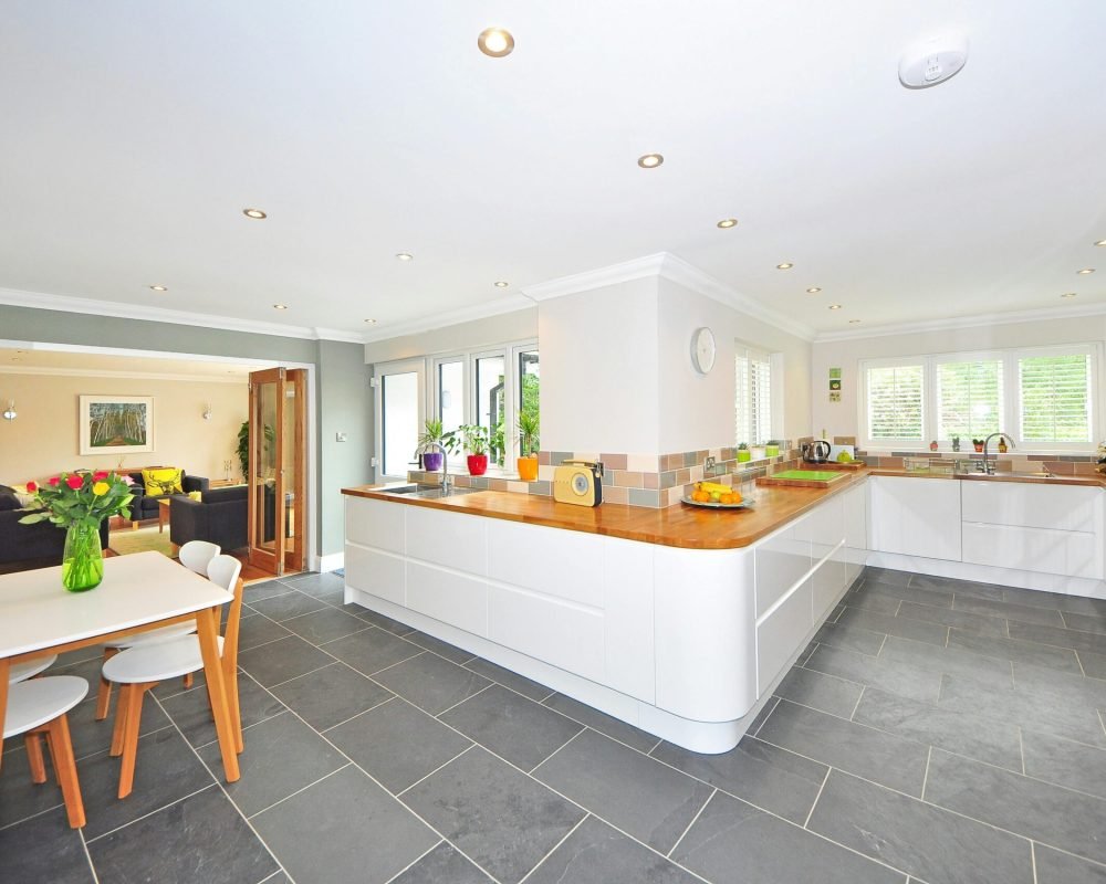 A spacious modern kitchen with elegant interiors featuring a dining table and luxurious design.